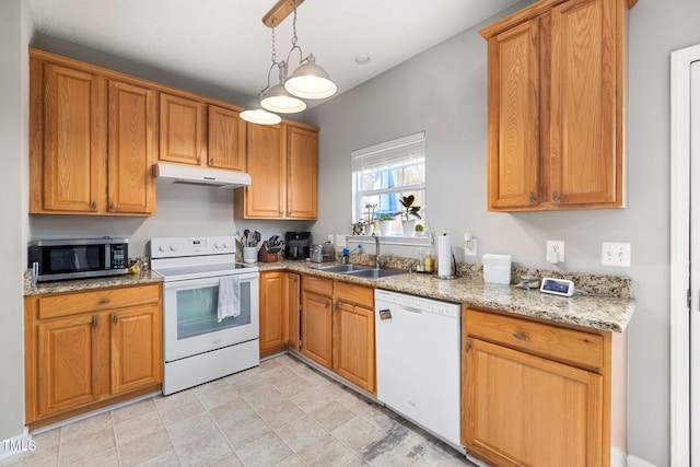 kitchen featuring pendant lighting, a sink, light stone counters, under cabinet range hood, and white appliances