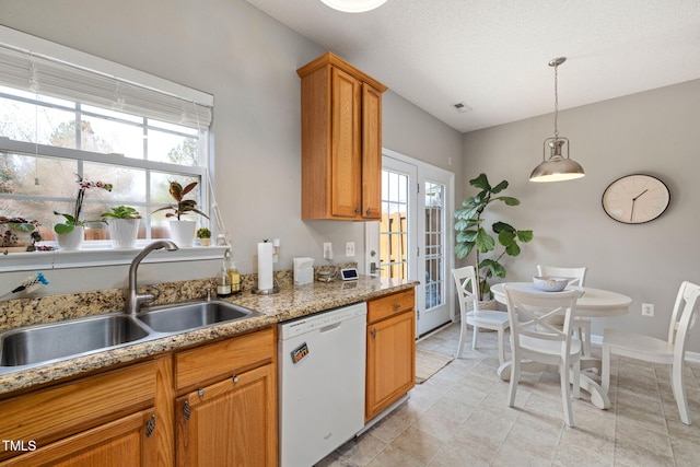 kitchen featuring a sink, pendant lighting, a wealth of natural light, and white dishwasher