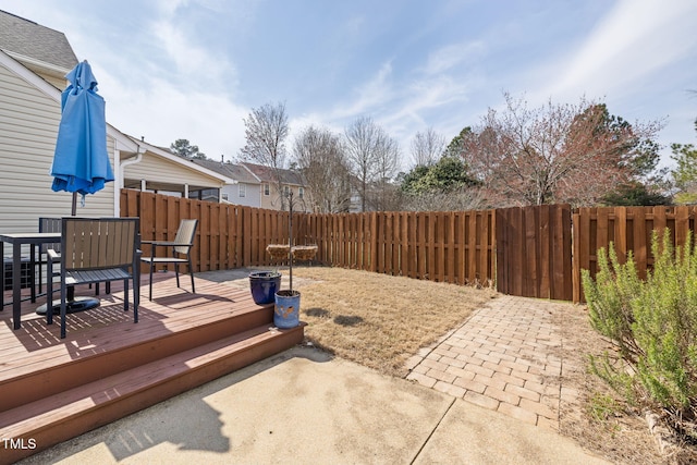 view of patio with outdoor dining space, a fenced backyard, and a wooden deck