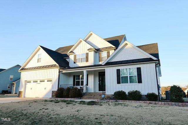 view of front of property featuring driveway, a standing seam roof, a porch, board and batten siding, and metal roof