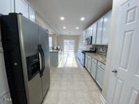 kitchen with recessed lighting, stainless steel fridge, decorative backsplash, and gas range oven