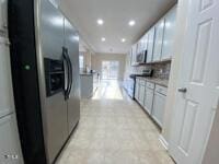 kitchen featuring recessed lighting, range, and stainless steel refrigerator with ice dispenser