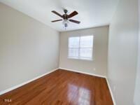 spare room featuring a ceiling fan, wood finished floors, and baseboards