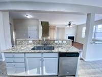 kitchen featuring stainless steel dishwasher, open floor plan, a fireplace, light countertops, and baseboards