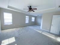 interior space featuring a raised ceiling, baseboards, and ceiling fan