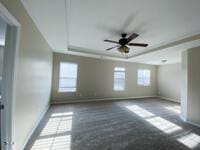 spare room with baseboards, a raised ceiling, and ceiling fan