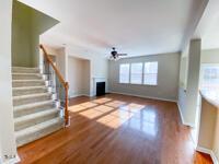 unfurnished living room featuring wood finished floors, stairway, a fireplace, and baseboards