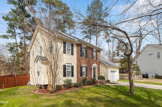 colonial house featuring a garage, a front lawn, driveway, and fence