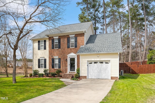 colonial house with a garage, roof with shingles, a front yard, and fence