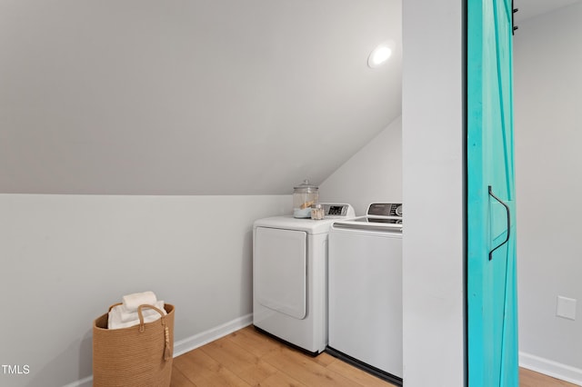 laundry area with light wood-type flooring, baseboards, laundry area, and washing machine and clothes dryer