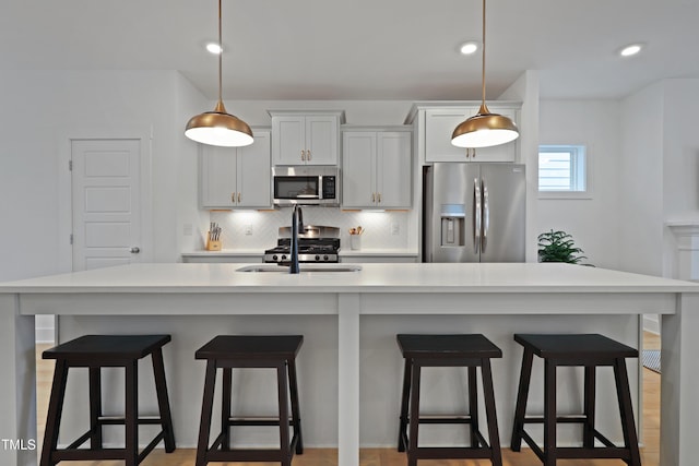 kitchen with decorative backsplash, appliances with stainless steel finishes, pendant lighting, and light countertops