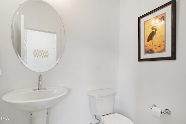 half bath featuring toilet and a sink