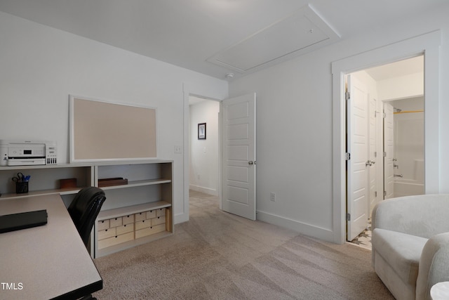 office space with baseboards, light colored carpet, and attic access
