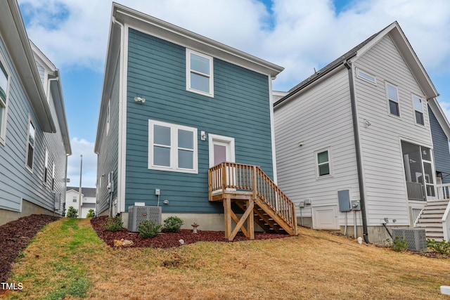 rear view of property featuring stairway, cooling unit, and a lawn
