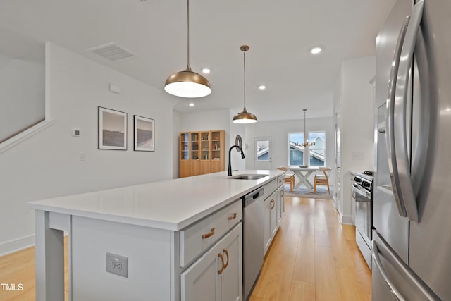 kitchen featuring visible vents, appliances with stainless steel finishes, light wood-type flooring, and a sink