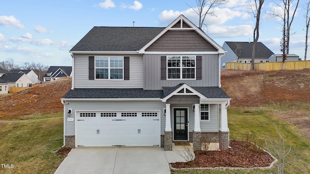 craftsman inspired home featuring driveway, board and batten siding, a front yard, a garage, and brick siding