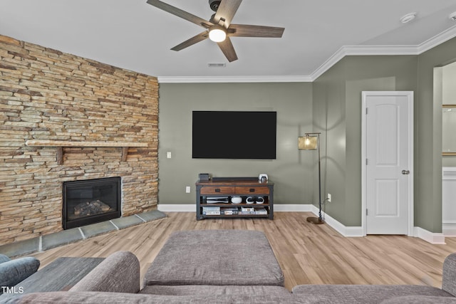 living area featuring a fireplace, crown molding, baseboards, and wood finished floors