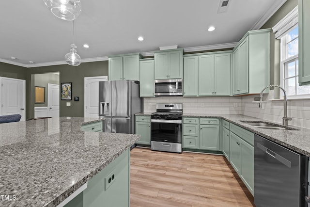 kitchen with visible vents, ornamental molding, a sink, appliances with stainless steel finishes, and green cabinets