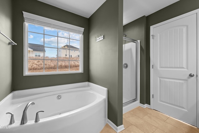 bathroom with tile patterned floors, a garden tub, baseboards, and a shower stall