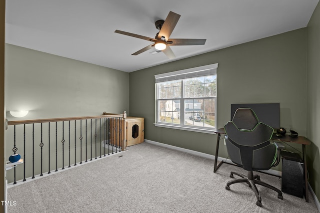 carpeted home office featuring baseboards and a ceiling fan