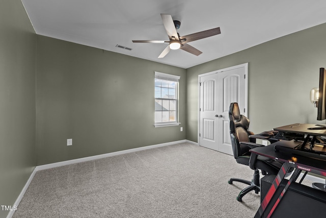 carpeted office with baseboards, visible vents, and ceiling fan