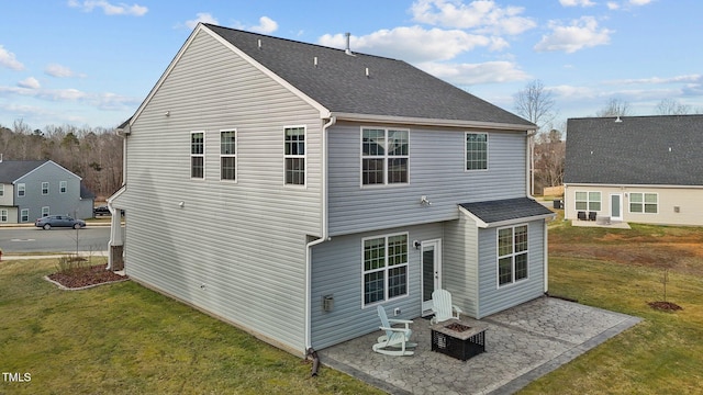 back of house featuring a shingled roof, a patio area, a lawn, and an outdoor fire pit