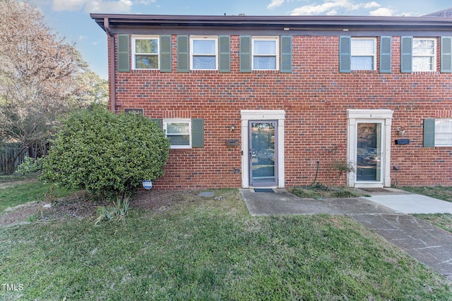 view of front of house featuring a front lawn and brick siding