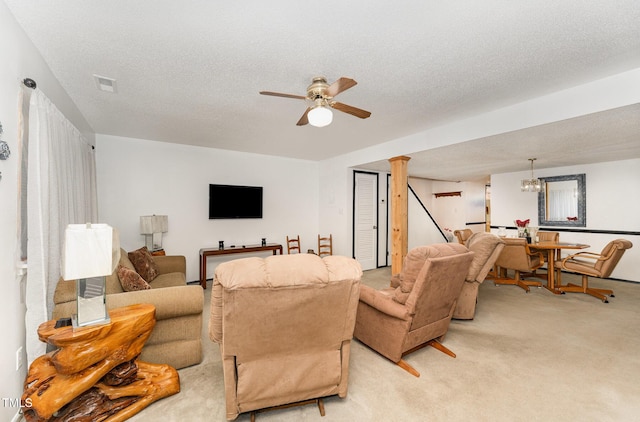 living area featuring a ceiling fan, light colored carpet, visible vents, and a textured ceiling