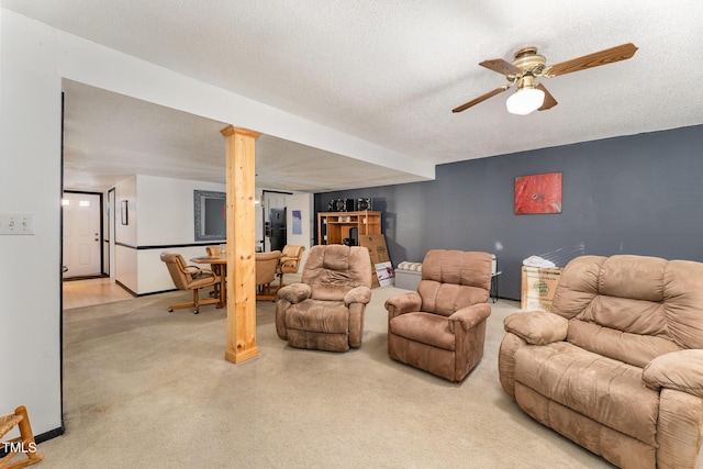 living area with carpet flooring, a ceiling fan, and a textured ceiling