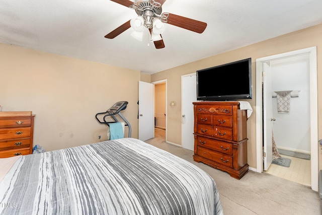 bedroom with light colored carpet, baseboards, ensuite bathroom, and ceiling fan