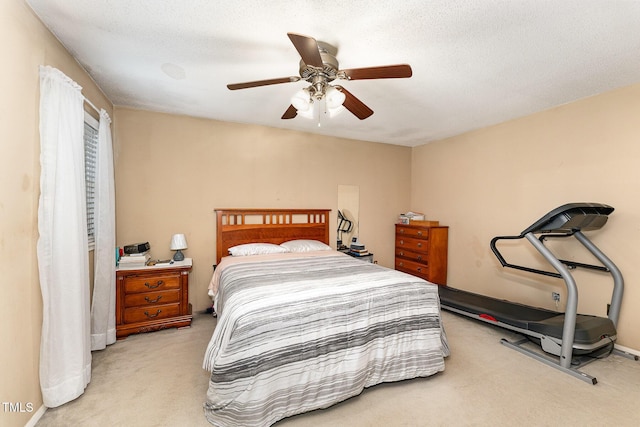 carpeted bedroom with a textured ceiling and a ceiling fan