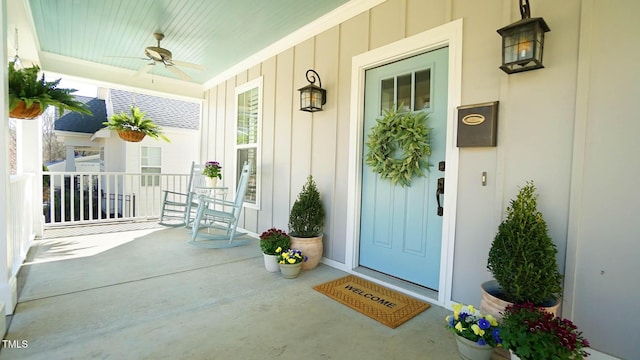 doorway to property with covered porch, board and batten siding, and a ceiling fan