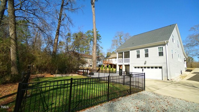 view of front of house featuring a garage, concrete driveway, a front lawn, and fence