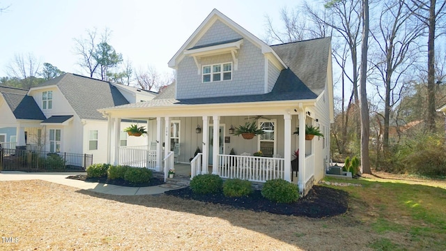 view of front of home with fence, covered porch, and roof with shingles