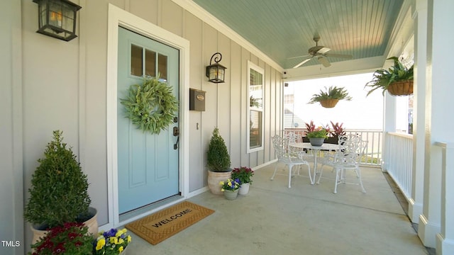 doorway to property featuring covered porch, board and batten siding, and a ceiling fan