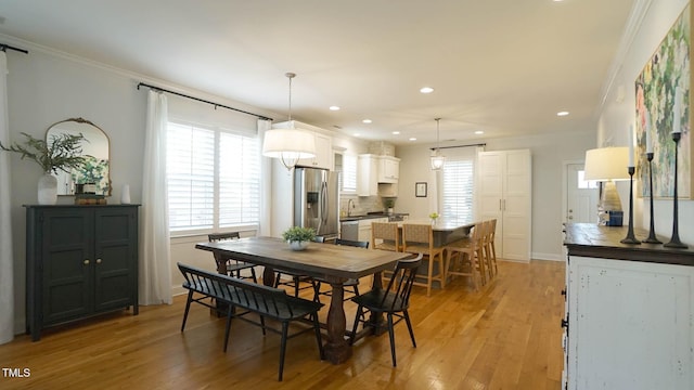 dining room with recessed lighting, light wood-type flooring, baseboards, and crown molding