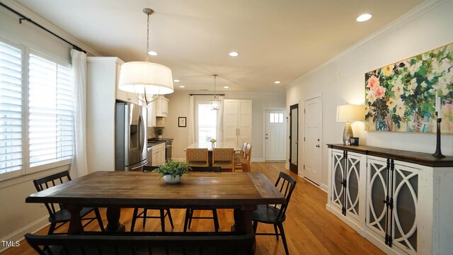 dining space featuring recessed lighting, light wood-type flooring, baseboards, and ornamental molding