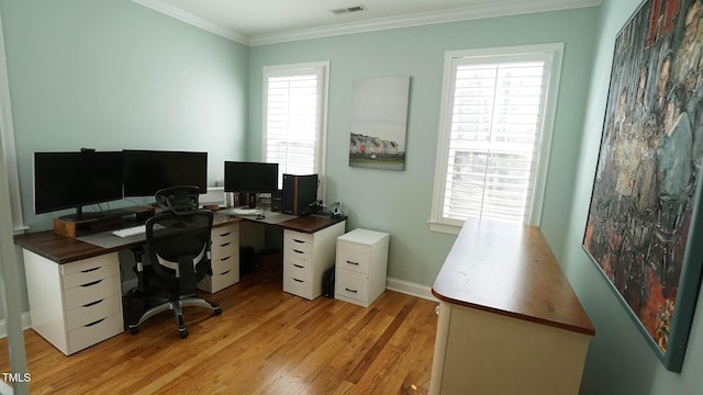 office space with baseboards, light wood-style floors, visible vents, and ornamental molding