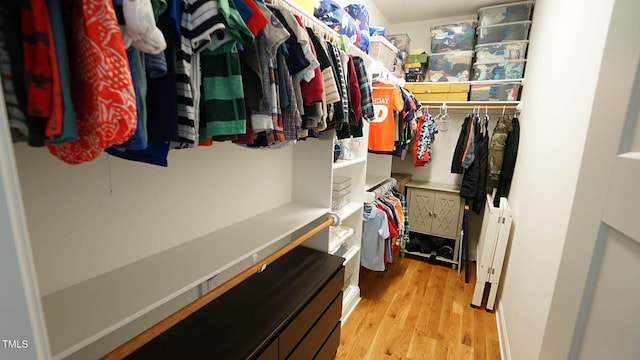 spacious closet with light wood-style flooring and radiator heating unit