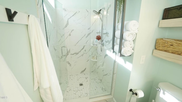 full bathroom with a marble finish shower and toilet