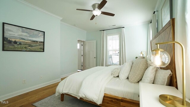 bedroom featuring ornamental molding, ceiling fan, baseboards, and wood finished floors