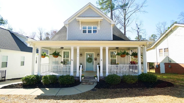 view of front of property with ceiling fan, board and batten siding, covered porch, and a shingled roof