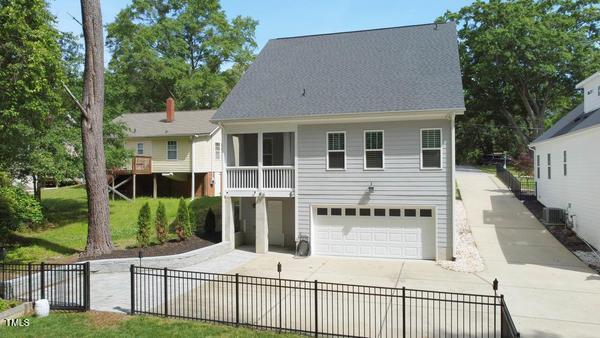 back of house featuring a garage, driveway, and fence