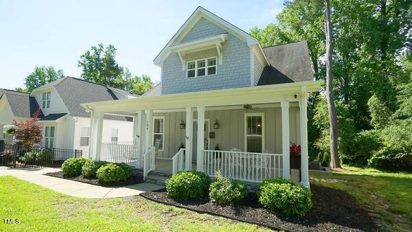 view of front of house featuring board and batten siding, covered porch, and a front lawn