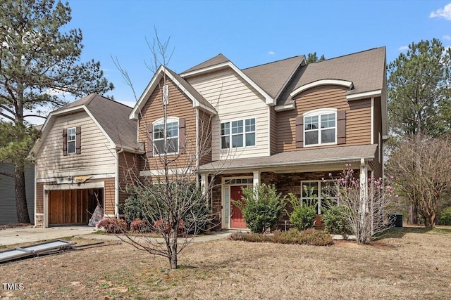 view of front of home featuring covered porch, a front lawn, concrete driveway, and a garage