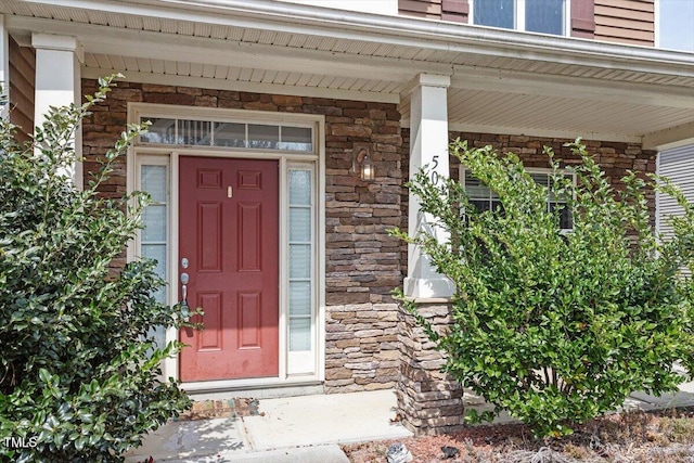 property entrance featuring a porch and stone siding