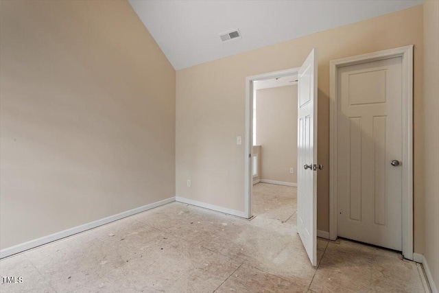 unfurnished bedroom featuring visible vents, baseboards, and vaulted ceiling