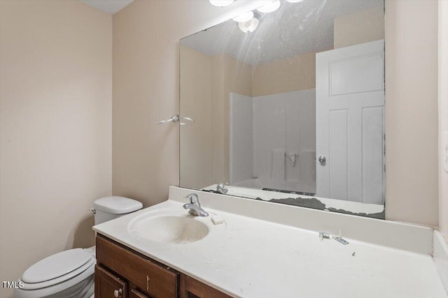 full bath with toilet, vanity, and walk in shower