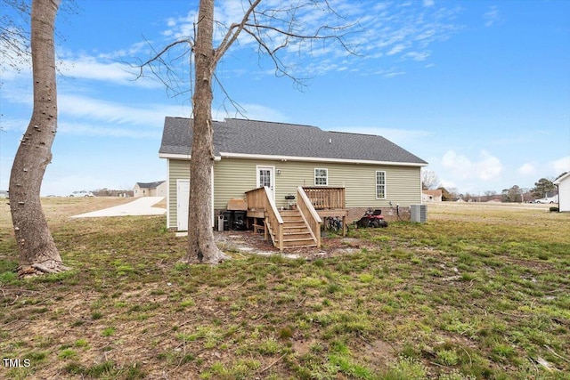 back of property featuring a shingled roof, stairway, central AC, a lawn, and a deck