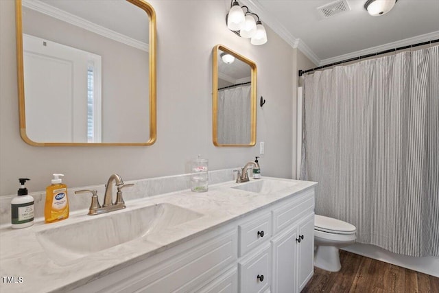 bathroom with a sink, visible vents, wood finished floors, and crown molding